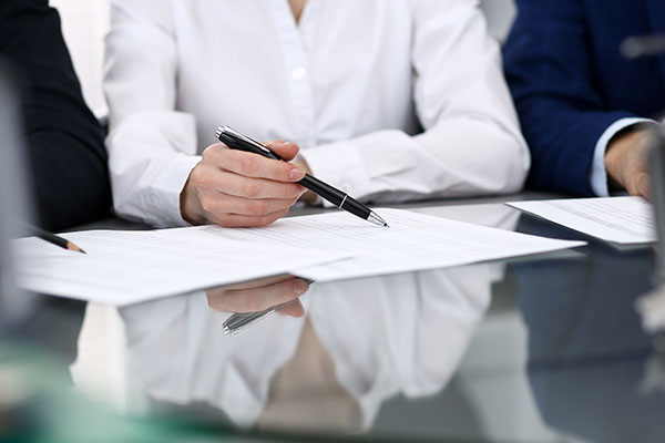 Business woman holding a pen and looking over paperwork