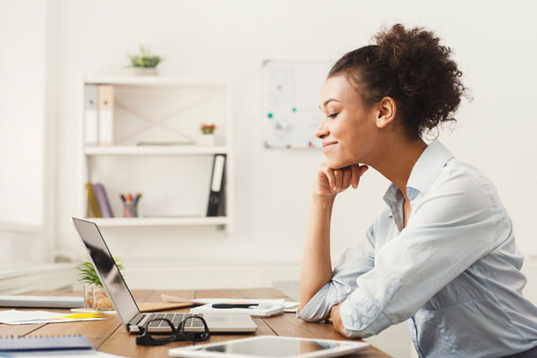 Business woman holding a pen and looking over paperwork